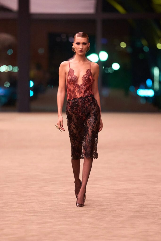 A model wears the Saint Laurent Fall 2026 silicone-coated lace bodysuit and skirt on the runway.