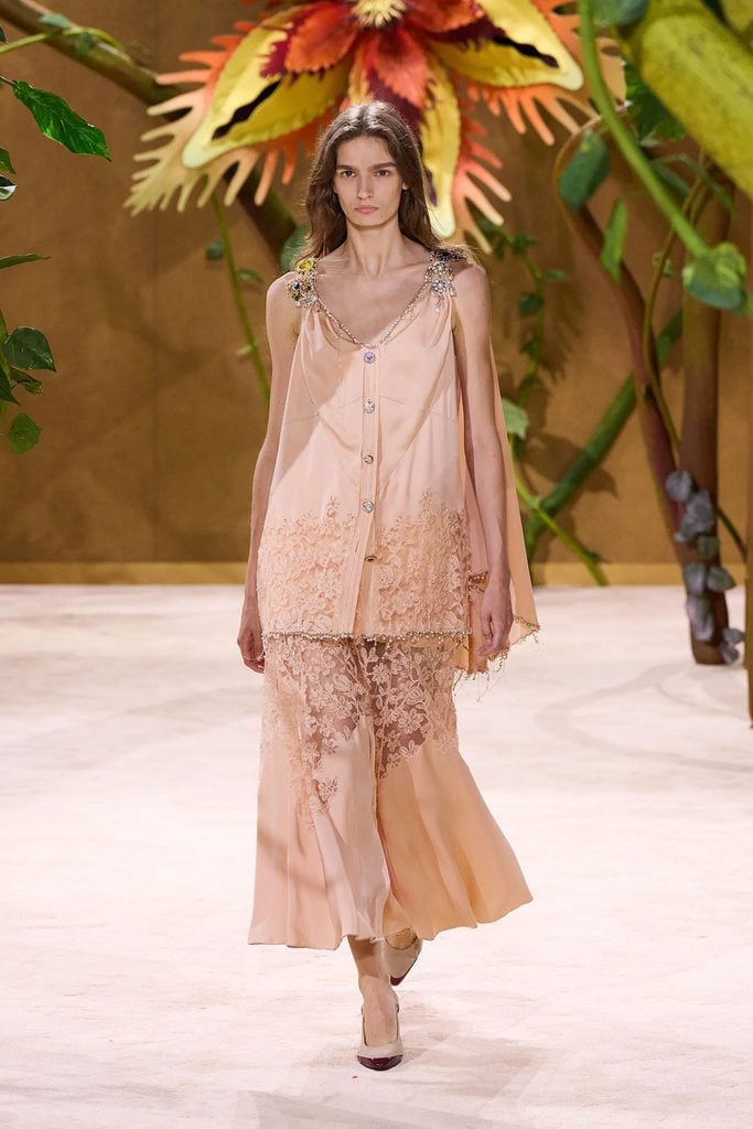 Chanel Fall 2026 Haute Couture peach satin and lace dress with jewelled shoulder details and a cape on the runway.