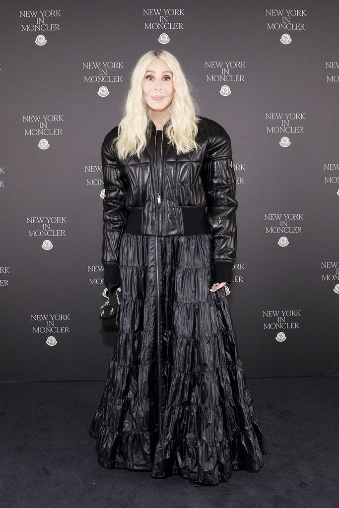 Cher wearing a black quilted Moncler jacket and tiered maxi skirt at the Fifth Avenue flagship opening in New York.