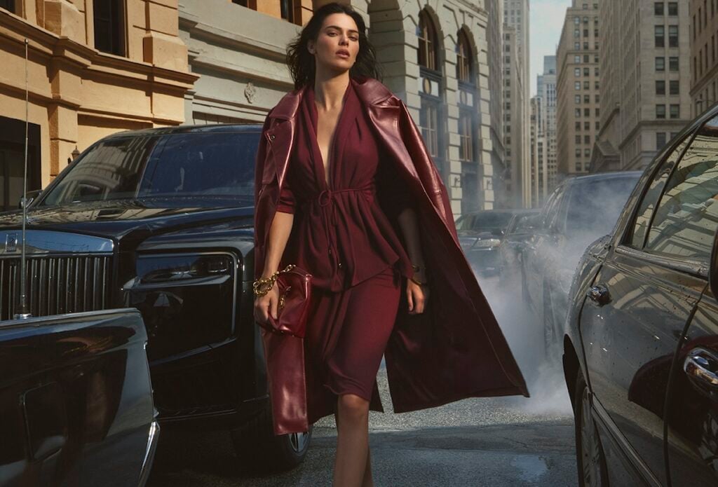 Kendall Jenner wears a black-cherry Donna Karan New York draped look with matching hosiery for the Fall 2026 campaign.