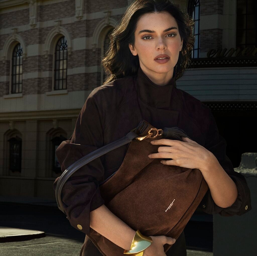 Kendall Jenner wears a brown Donna Karan New York look with the Cashmere Tote in Chocolate Suede for the Fall 2026 campaign.