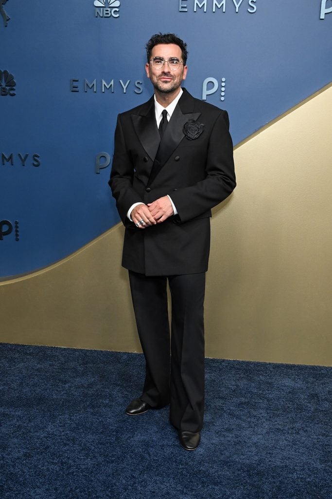 Dan Levy wearing a black double-breasted Celine tuxedo with a tonal flower brooch at the 2026 Emmy Awards.