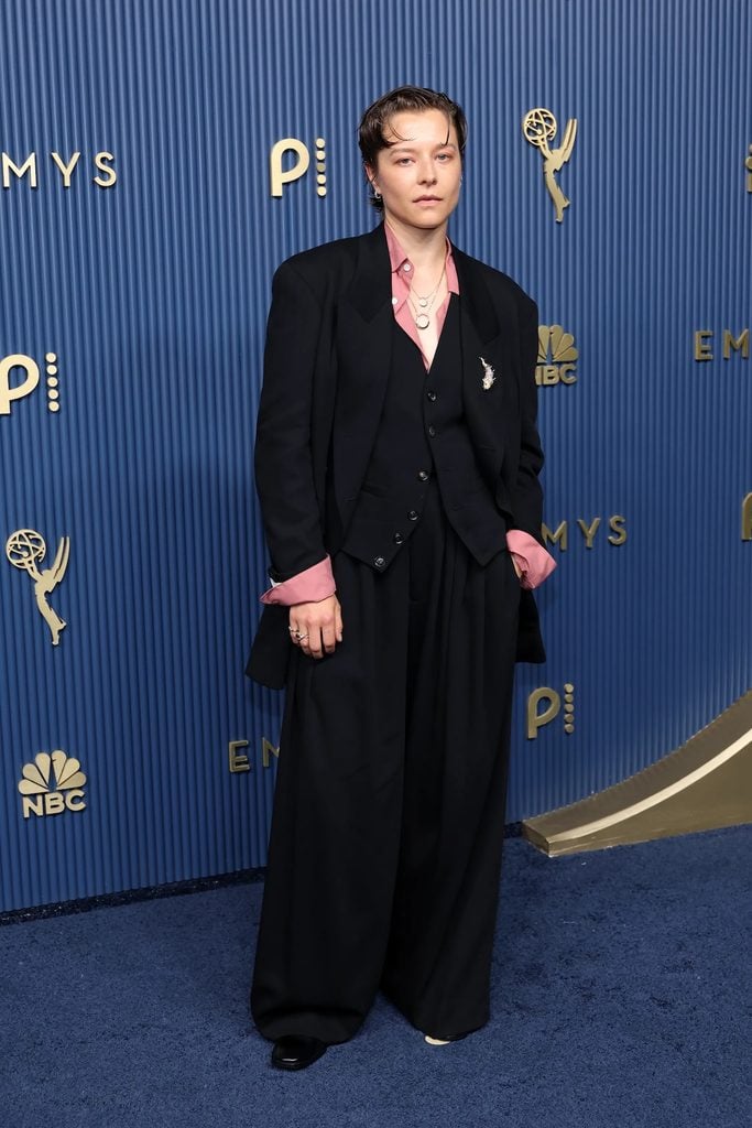 Emma D’Arcy wearing an oversized black Soshiotsuki three-piece suit with a pink shirt at the 2026 Emmy Awards.