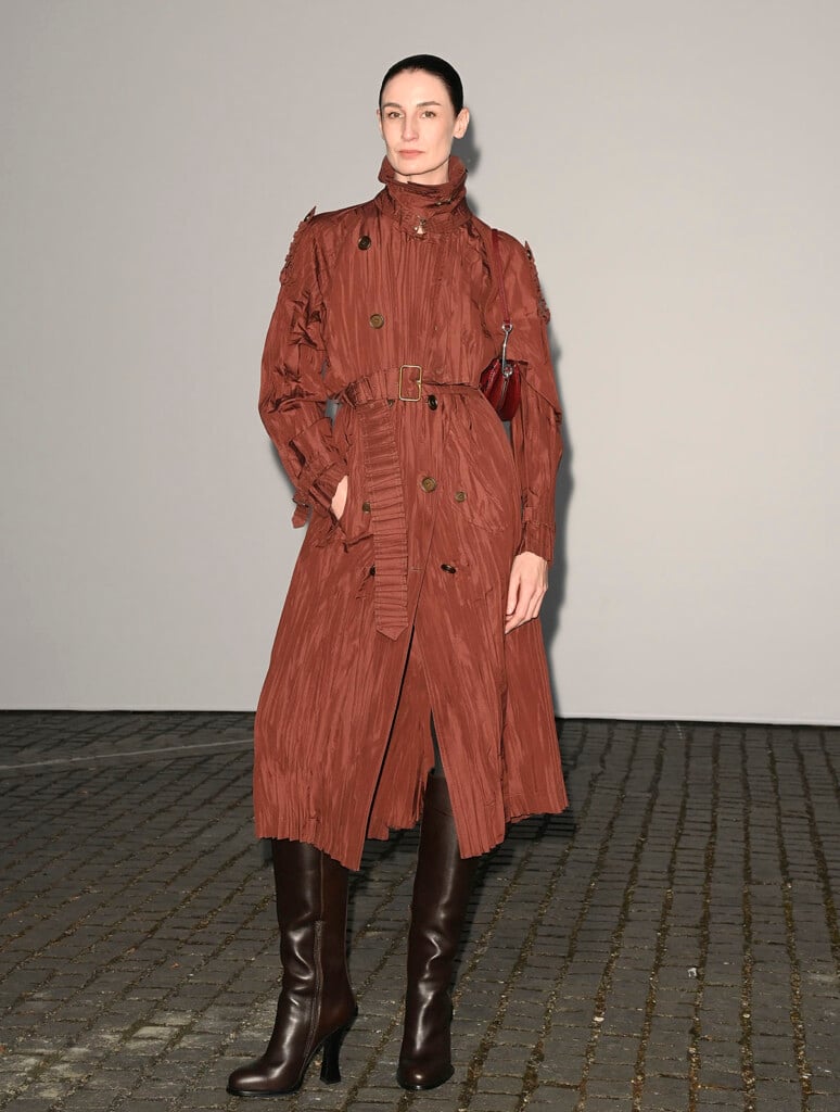 Erin O’Connor wearing a textured rust Burberry trench coat at the Burberry Summer 2027 show in London