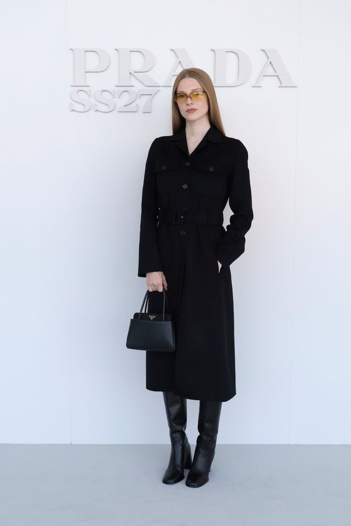 Hunter Schafer wearing a black Prada coat at the Spring/Summer 2027 womenswear show in Milan.