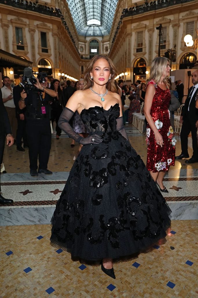 Jennifer Lopez wearing a black Dolce & Gabbana Alta Moda corseted floral dress with sheer gloves and an aquamarine necklace at Vogue World Milano.