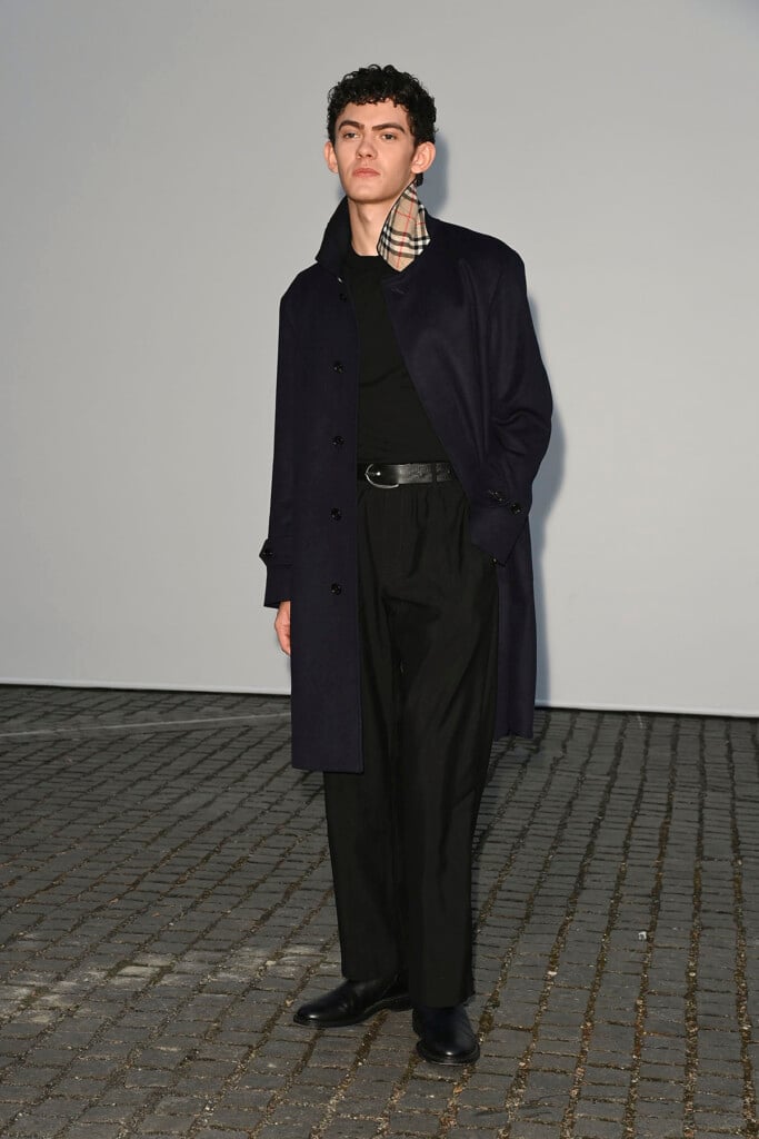 Joe Locke wearing a dark Burberry trench coat with Burberry Check detailing at the Summer 2027 show in London