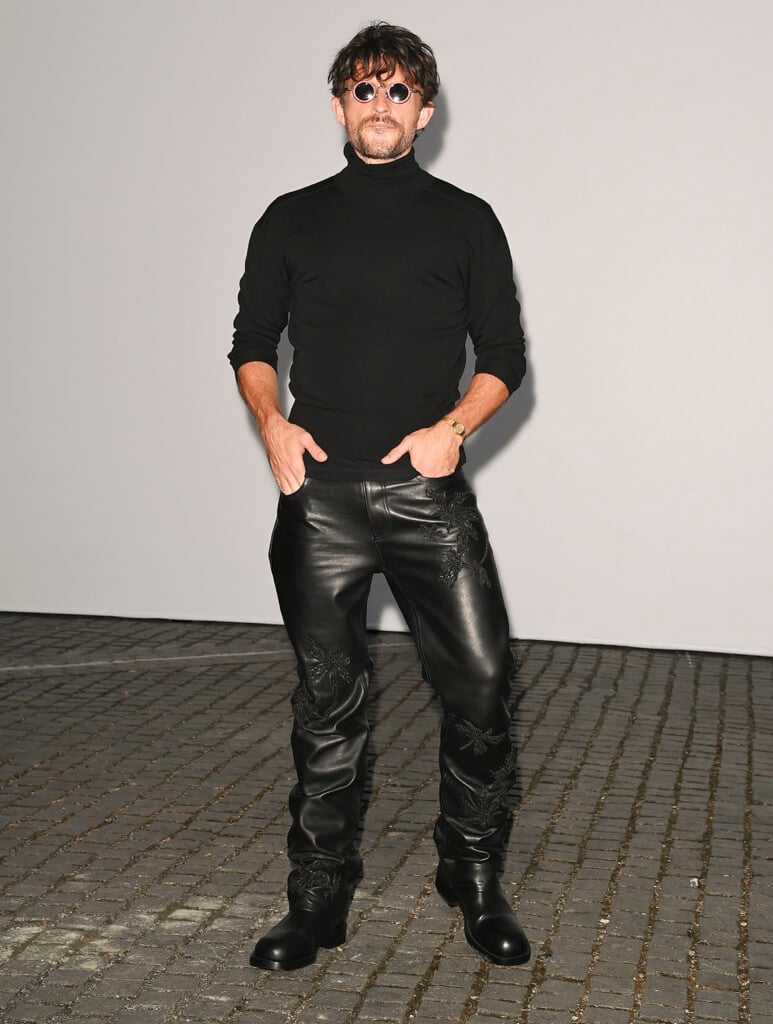 Jonathan Bailey wearing embroidered black leather Burberry trousers at the Burberry Summer 2027 show in London