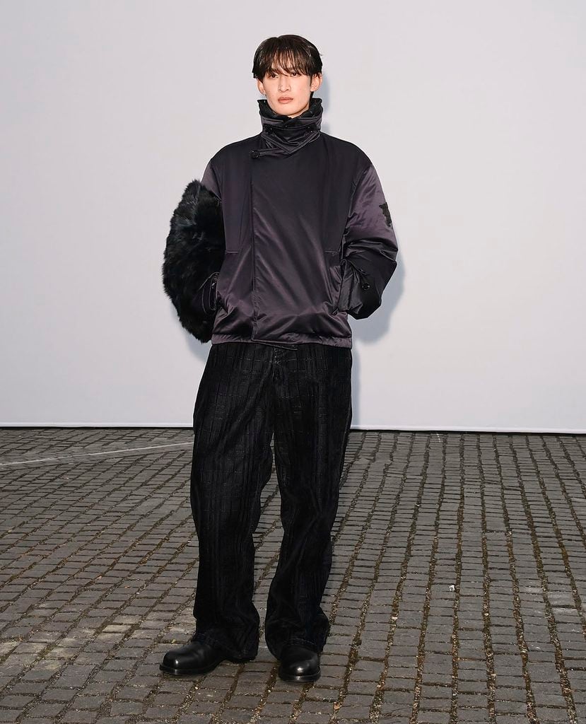 Koji Mukai wearing a high-neck Burberry utility jacket and relaxed trousers at the Burberry Summer 2027 show in London
