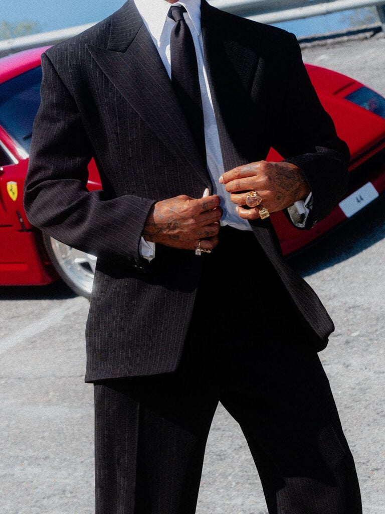 Lewis Hamilton wears a black pinstripe Saint Laurent suit at the F1 Italian Grand Prix in Monza close up with Renato Cipullo’s Beryl Topiary ring