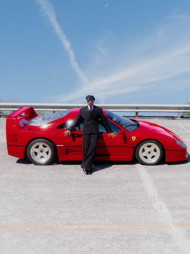 Lewis Hamilton wears a black pinstripe Saint Laurent suit at the F1 Italian Grand Prix in Monza with Ferrari 44 car