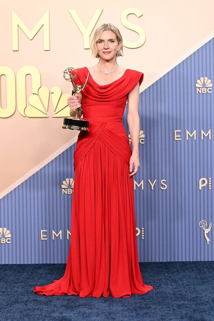 Rhea Seehorn holding her Lead Actress Emmy for ‘Pluribus’ while wearing a custom red Louis Vuitton gown.