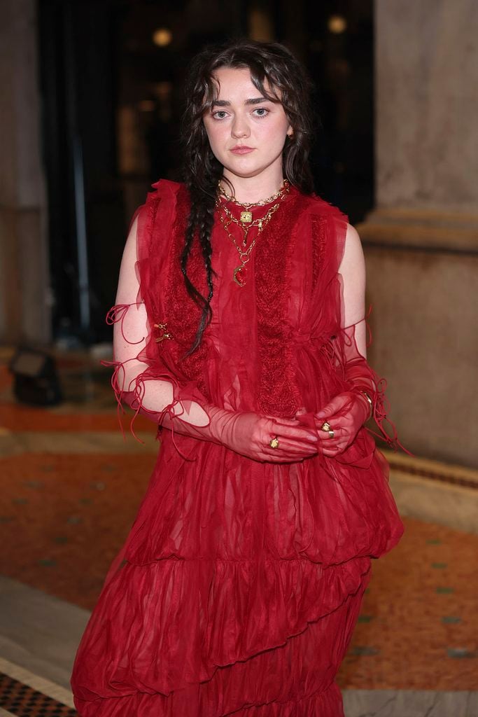 Maisie Williams wearing a red Pauline Dujancourt tulle look with sheer gloves and layered jewellery at Vogue World Milano.