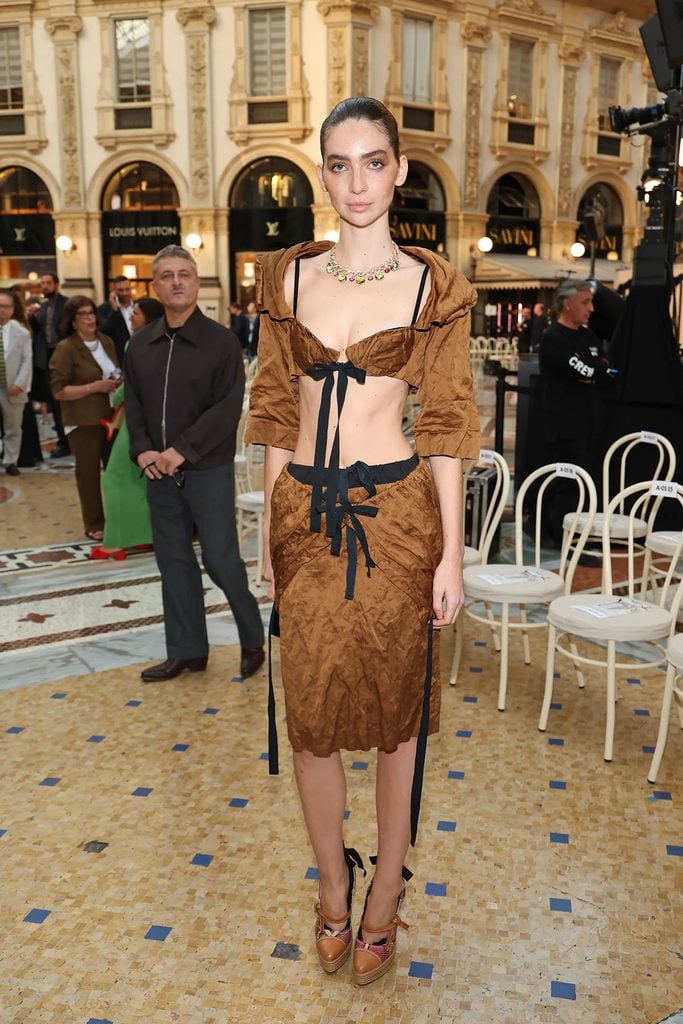 Meadow Walker wearing a brown Prada Spring 2009 cropped top and matching skirt with black ribbon details at Vogue World Milano.