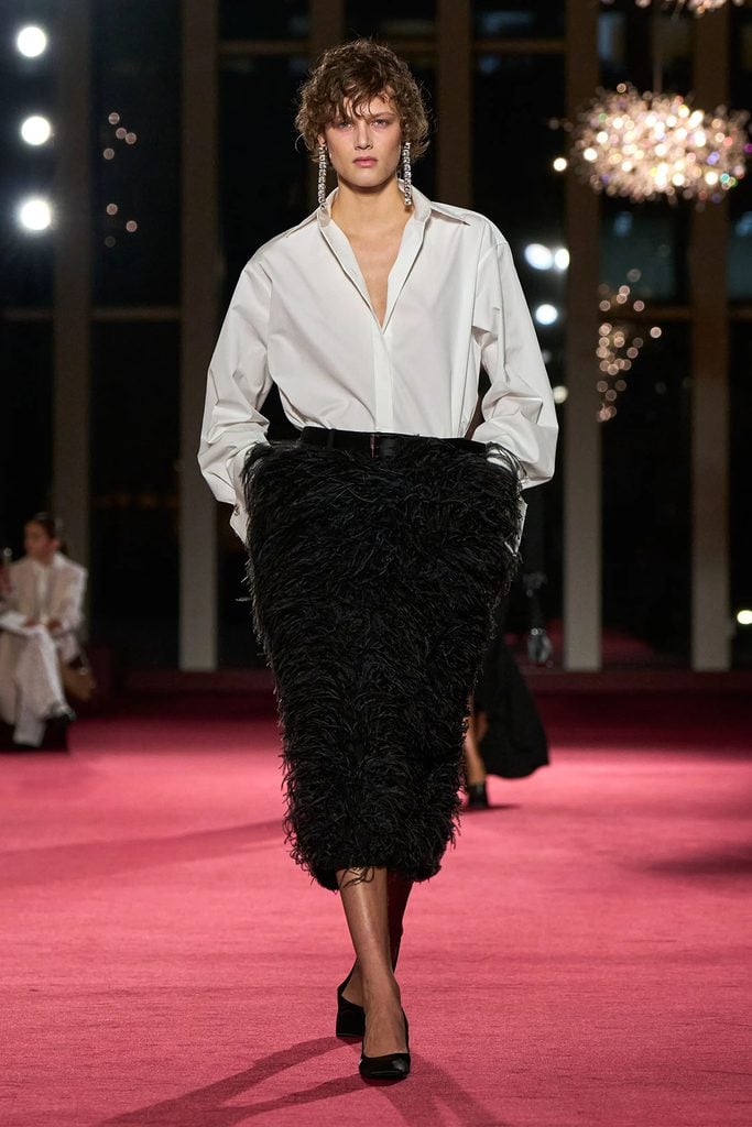 Michael Kors Collection Fall 2026 feathered trouser skirt with an oversized white shirt on the runway