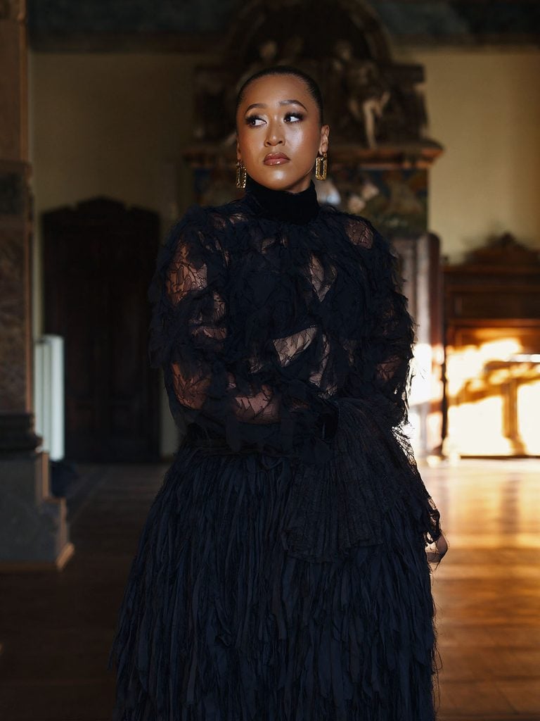Naomi Osaka in a sheer black Roberto Cavalli blouse and full crinoline skirt with gold earrings at Vogue World Milano