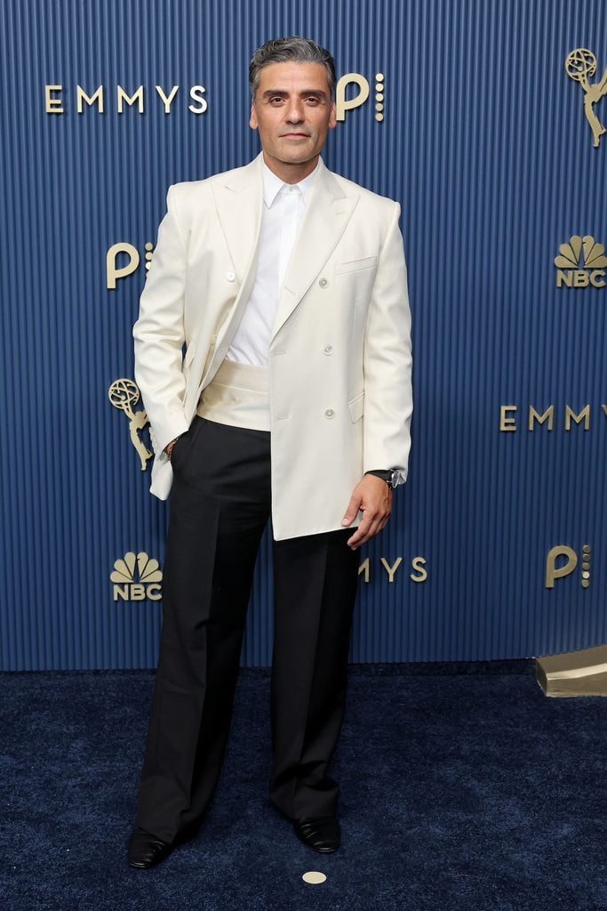 Oscar Isaac wearing a white double-breasted Celine tuxedo jacket with black trousers at the 2026 Emmy Awards.