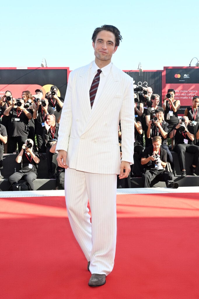 Robert Pattinson wears a white pinstriped Dior suit to the Primetime premiere at the Venice Film Festival.