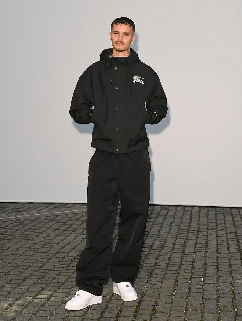 Romeo Beckham wearing a black Burberry hooded jacket and relaxed trousers at the Burberry Summer 2027 show in London