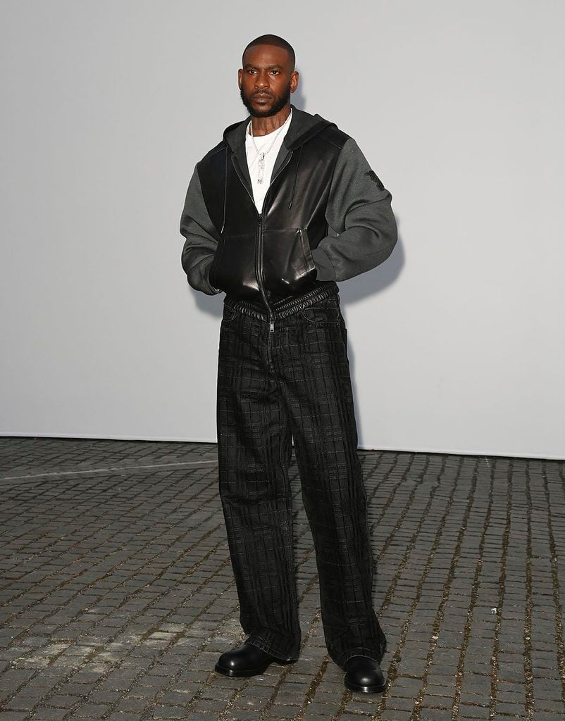 Skepta wearing a Burberry leather-panelled hooded jacket and wide-leg trousers at the Summer 2027 show in London