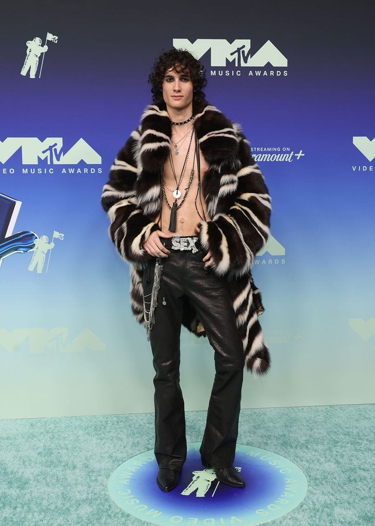 Sombr wearing a custom ERL faux-fur skunk coat with black leather trousers at the 2026 MTV VMAs.