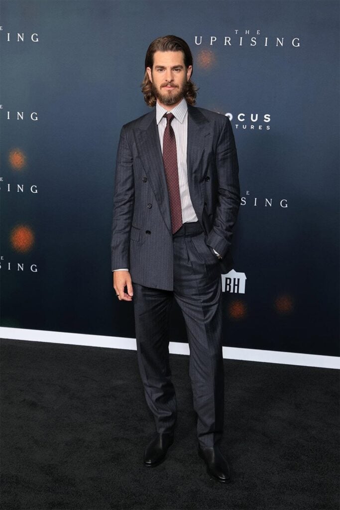 Andrew Garfield wears a dark pinstripe Loro Piana double-breasted suit to The Uprising Los Angeles premiere.
