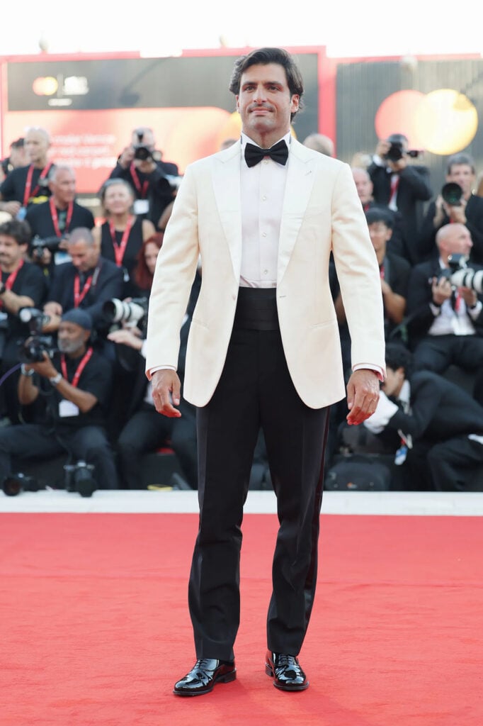Carlos Sainz Jr. wearing a Giorgio Armani Made to Measure ivory dinner jacket and black trousers at the 2026 Venice Film Festival.