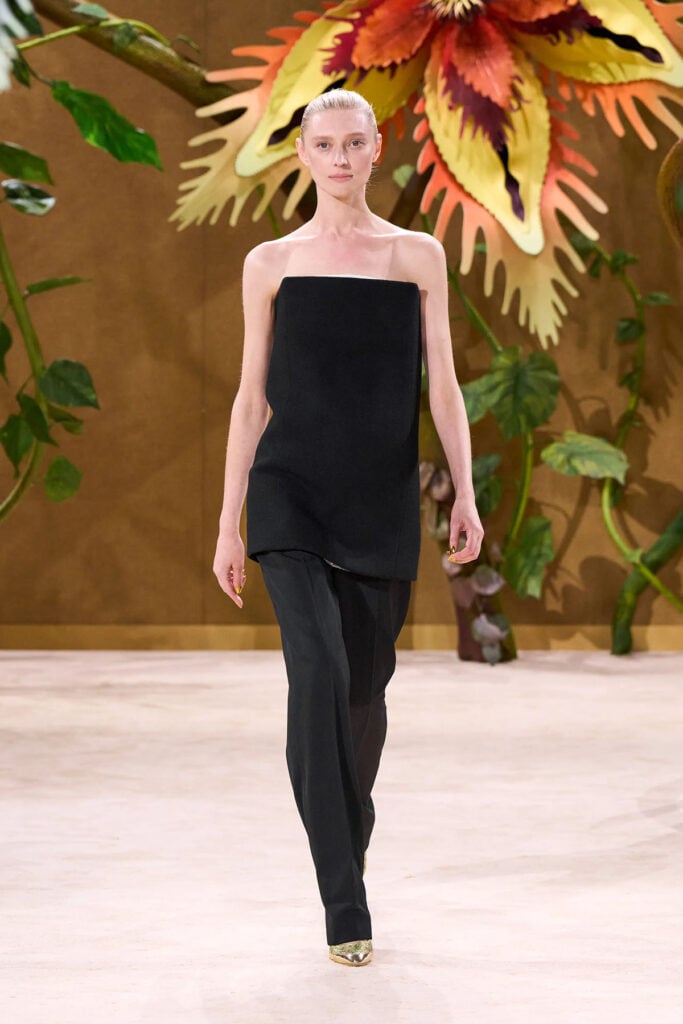 A model wears the black bustier and trouser look from the Chanel Fall 2026 Haute Couture collection on the runway.