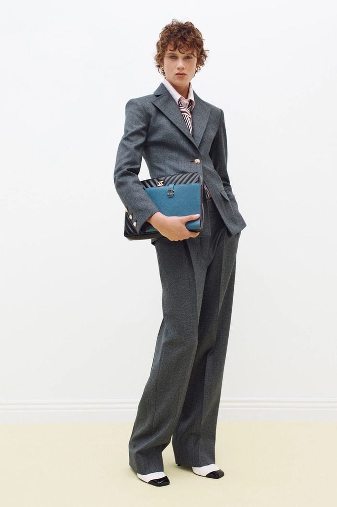Chanel Pre-Fall 2026 charcoal suit with a pink shirt, striped tie and two-tone pumps from the lookbook