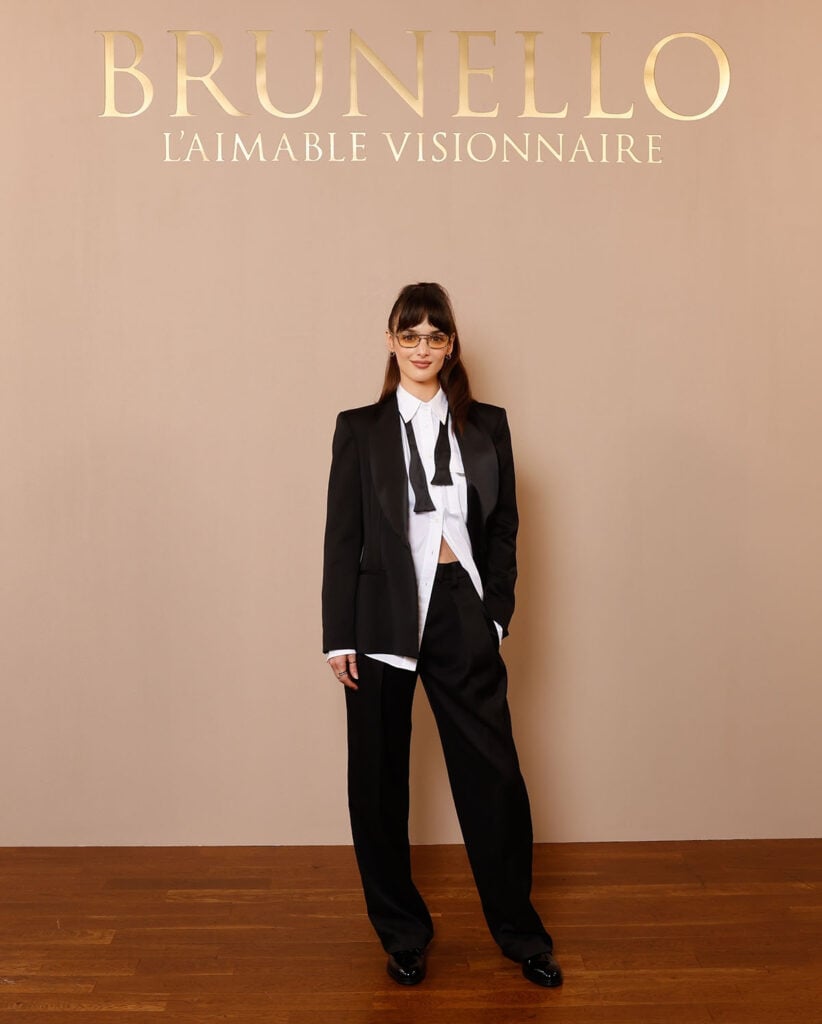 Charlotte Le Bon wears Brunello Cucinelli tailoring with a white shirt and undone bow tie at the brand’s Paris boutique celebration.