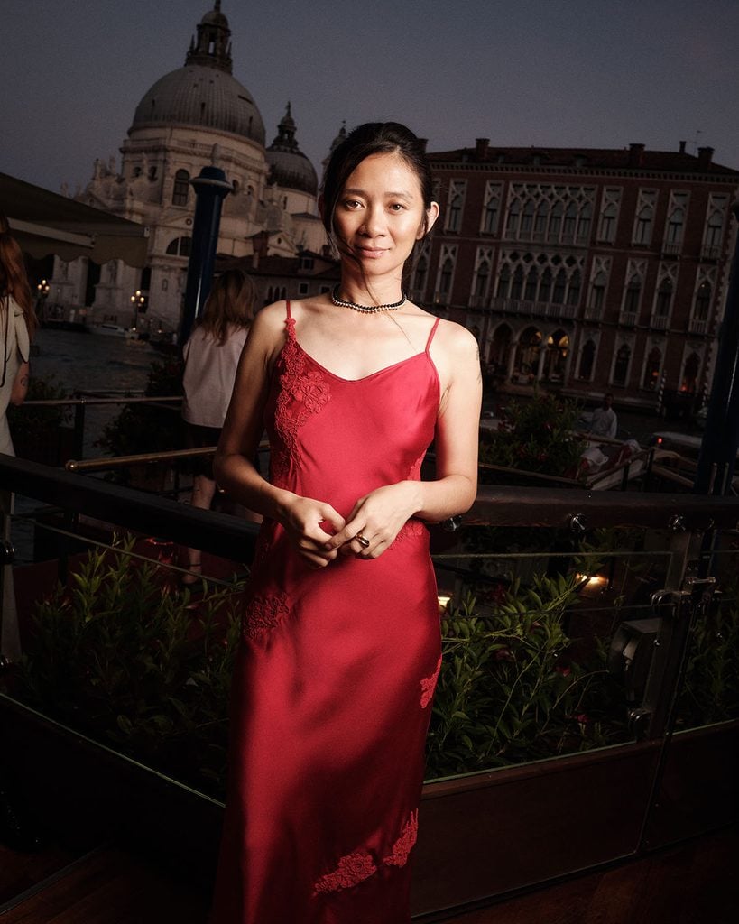 Chloé Zhao wearing a red Kami Speer slip dress with Cartier jewellery at the Cartier Cinema Club in Venice.