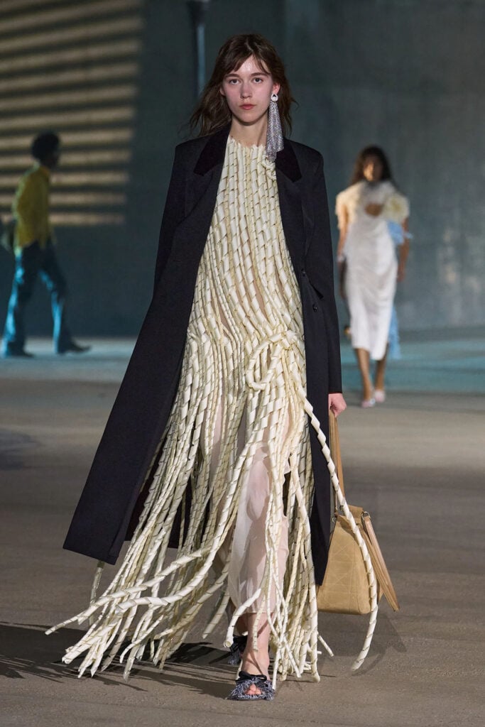 A model wears the white shredded-effect Dior Resort 2027 dress from the collection.