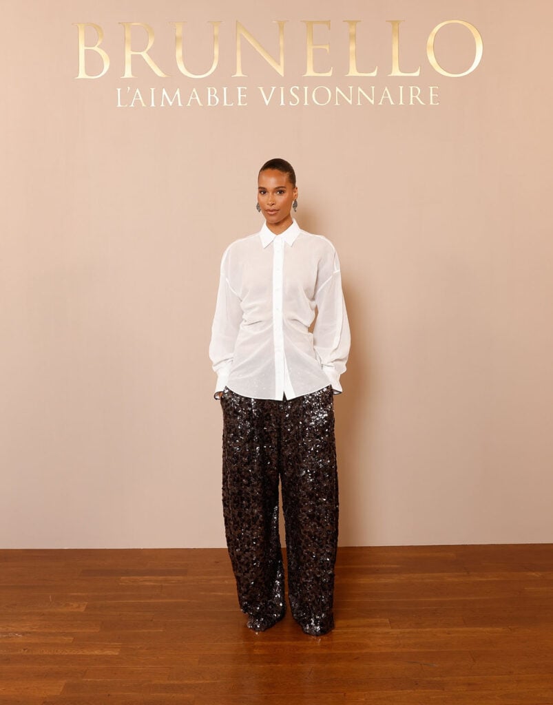 Cindy Bruna pairs a sheer white Brunello Cucinelli shirt with sequin trousers at the Brunello Cucinelli Paris boutique celebration.