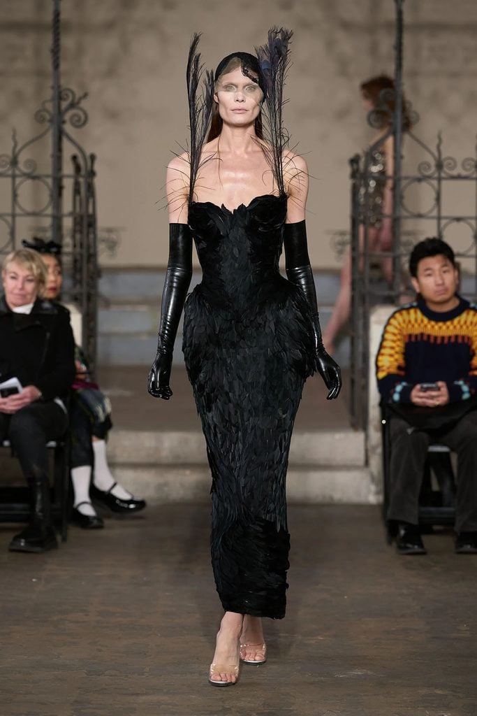 Dilara Fındıkoğlu Fall 2023 Dark Phoenix dress styled with long black latex gloves and feather details on the runway.