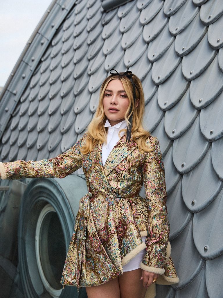 Florence Pugh wearing a floral Dior jacket with pink bow sandals and a matching ribbon in her hair while promoting 'East of Eden' in London.