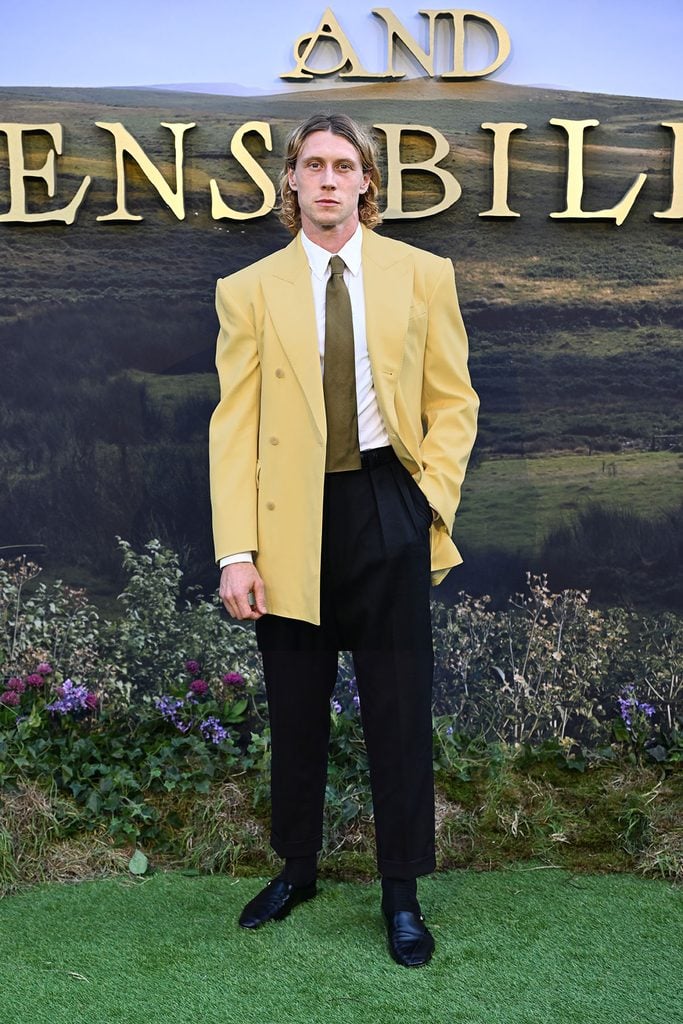 George MacKay wears a pale-yellow Celine blazer with black trousers at the Sense and Sensibility London premiere