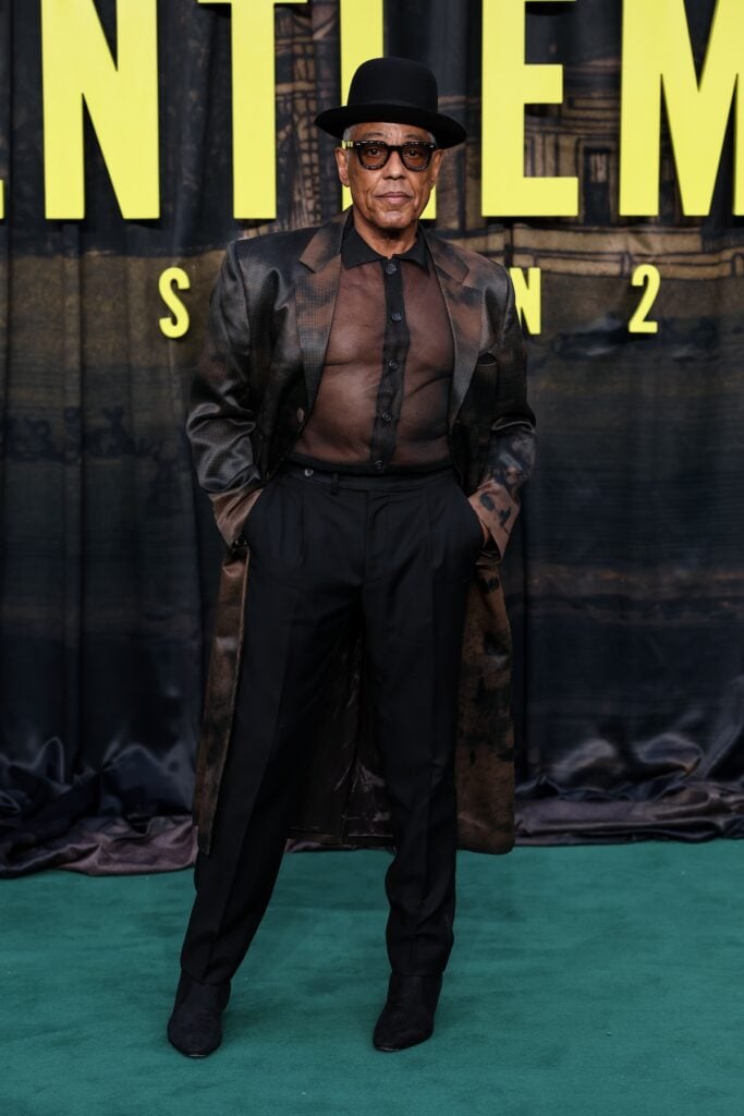 Giancarlo Esposito wears Denzil Patrick with a sheer shirt and patterned coat at The Gentlemen Season 2 London premiere.