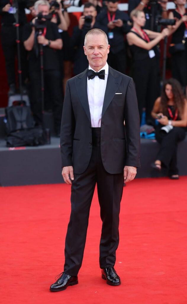 Guy Pearce wearing a black Brunello Cucinelli tuxedo with a bow tie and cummerbund at the Ink premiere in Venice.