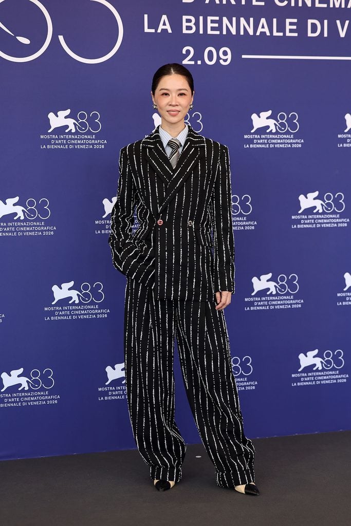 Hsieh Ying-Xuan wearing a Chanel Pre-Fall 2026 pinstriped suit at the Arrested Memory photocall during the Venice Film Festival.