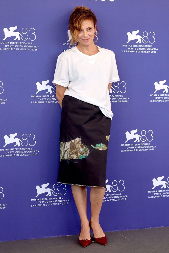 Jasmine Trinca wearing a Prada T-shirt and devoré midi skirt at the L'Estranea photocall during the 2026 Venice Film Festival.