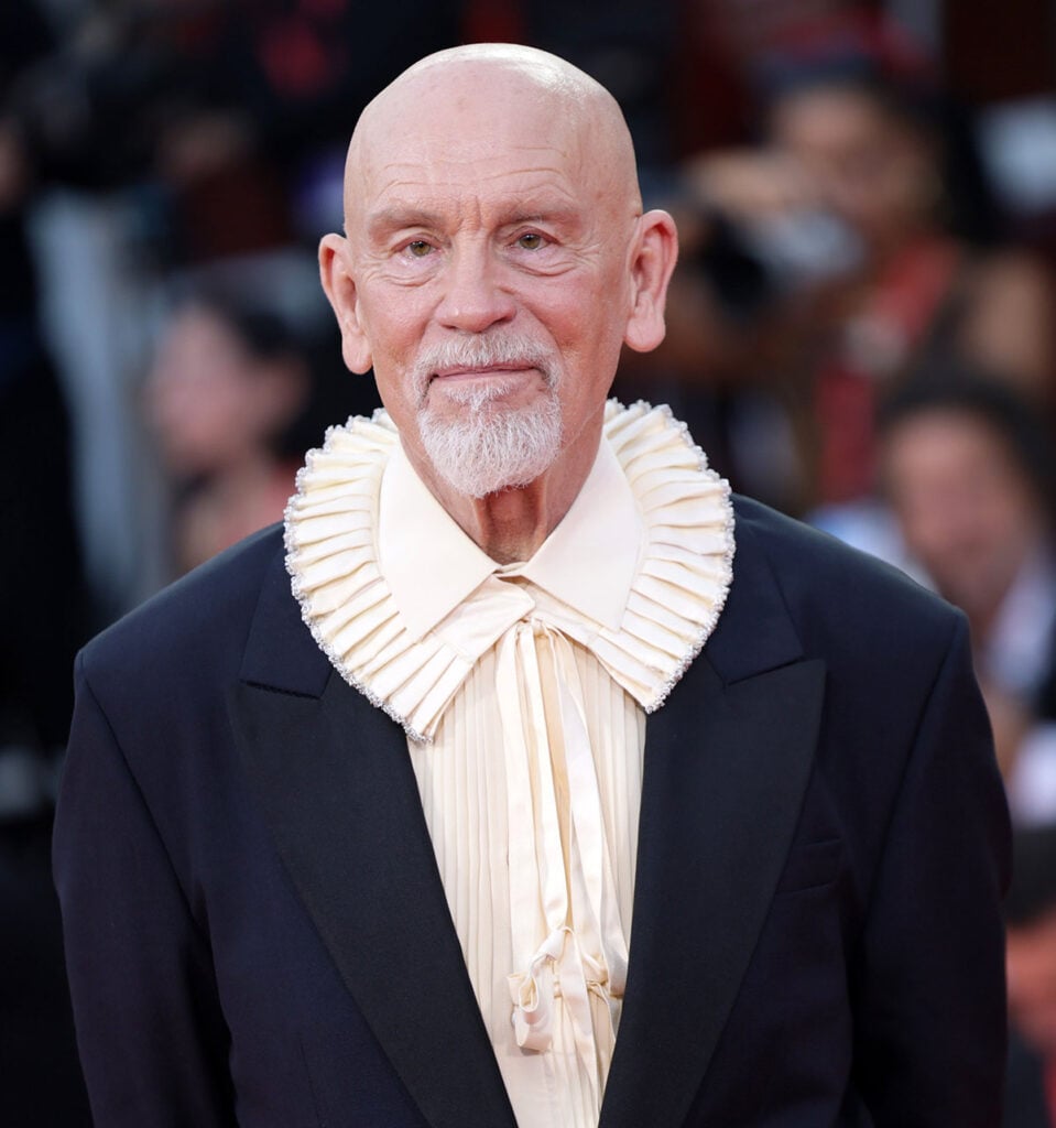 John Malkovich wearing a black Dior Fall 2026 dramatic pleated collar at the Wild Horse Nine Venice Film Festival premiere.