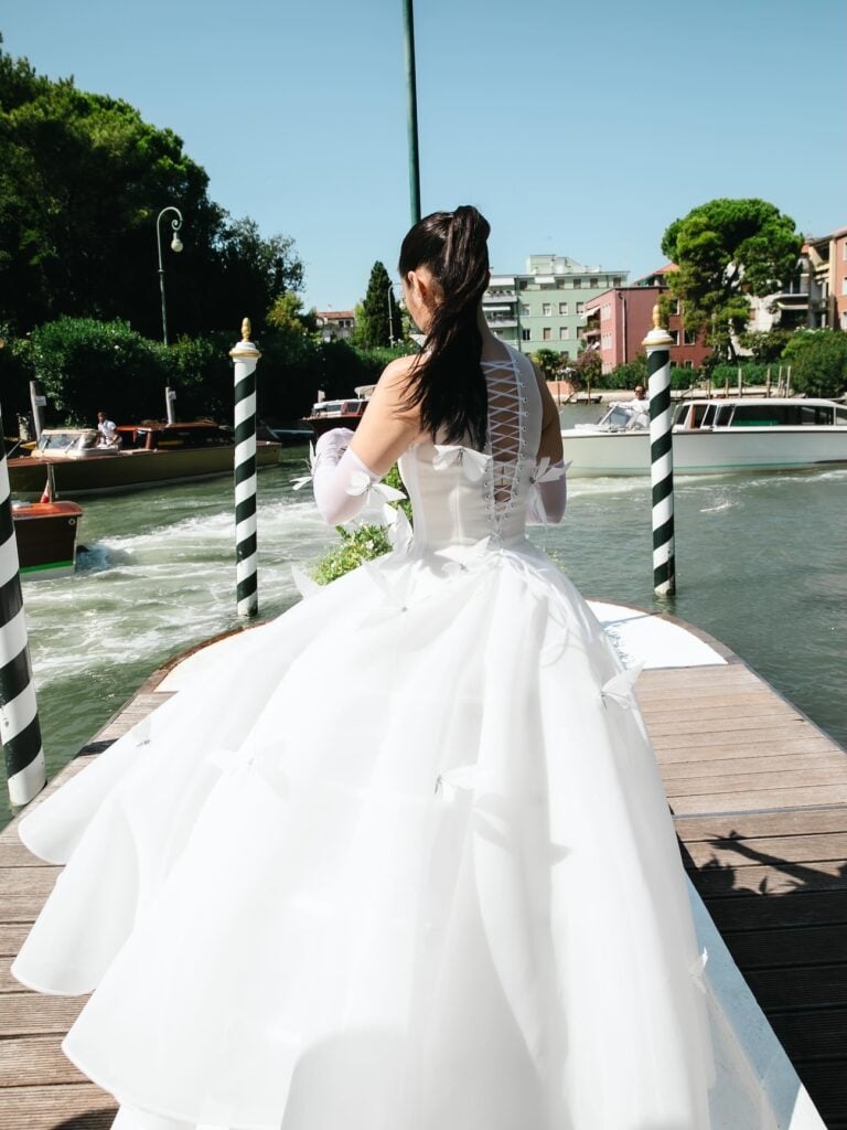 Liza Soberano reveals the lace-up back and voluminous skirt of her Robert Wun butterfly gown during the Venice Film Festival.