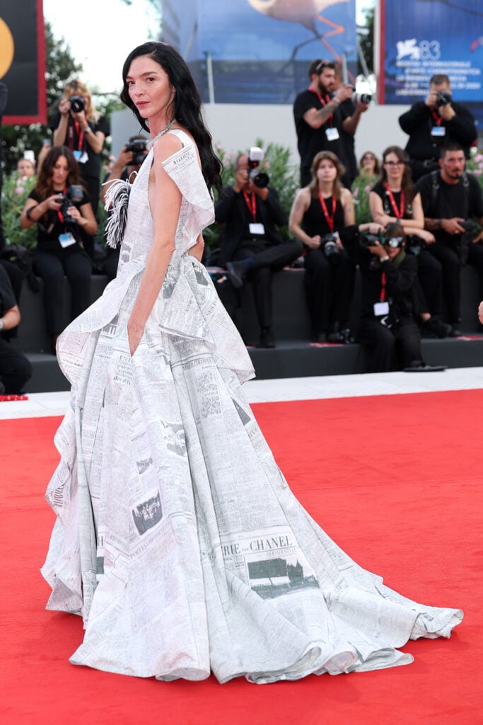 Mariacarla Boscono shows the cascading construction of her Chanel Resort 2027 newspaper-print gown at the Venice Film Festival.