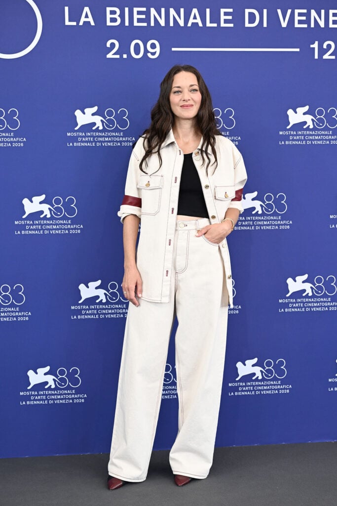Marion Cotillard wears an ecru Chanel denim overshirt and matching wide-leg jeans to the Biennale College Cinema photocall in Venice.