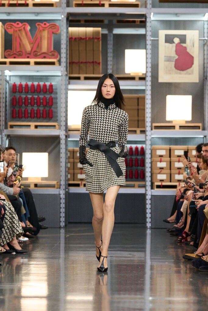 Max Mara Resort 2027 runway look worn by Kate Mara during the 2026 Venice Film Festival, styled with an oversized black bow and gloves.
