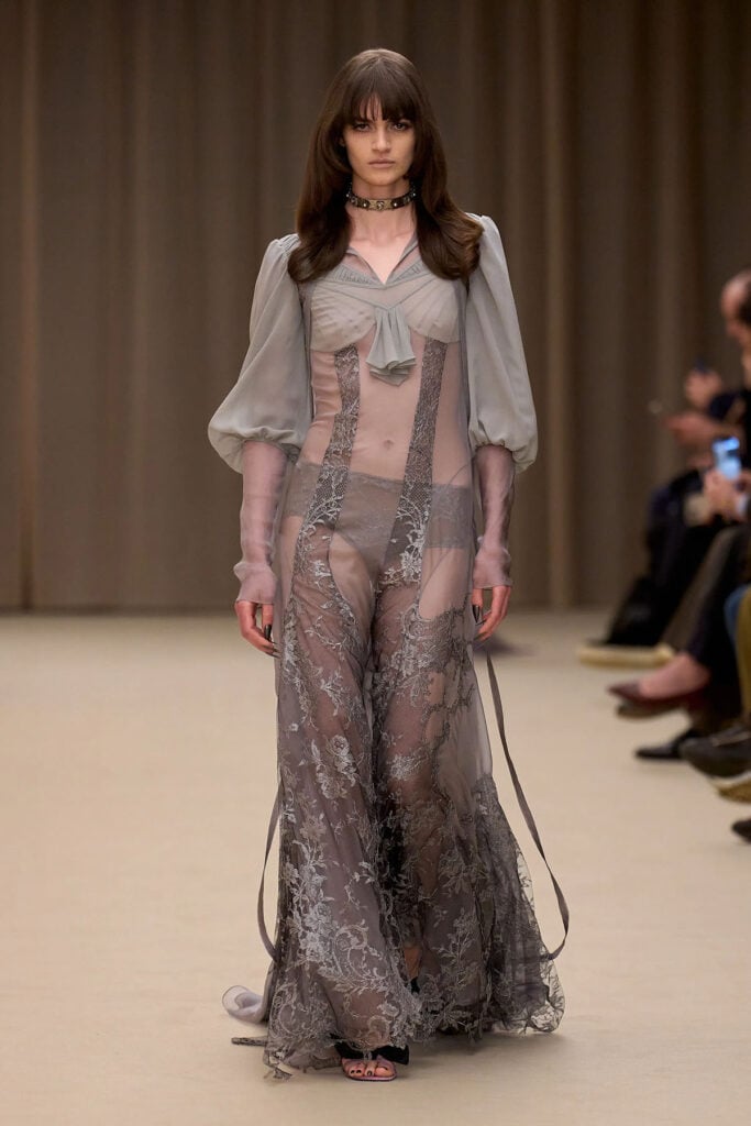 A model wears the grey sheer lace McQueen Fall 2026 gown on the runway.