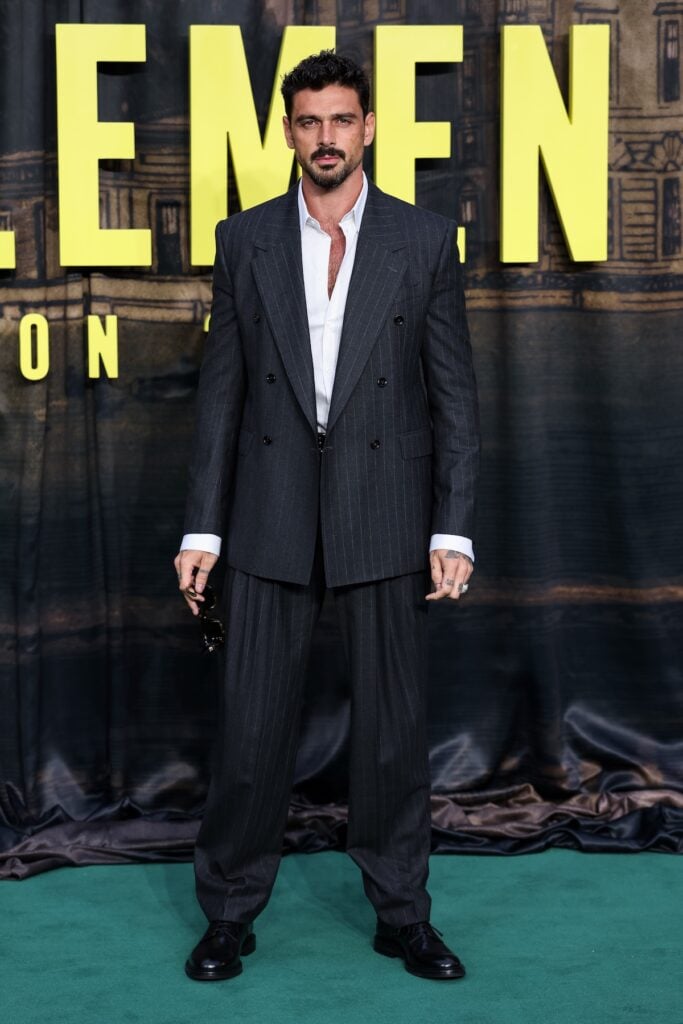 Michele Morrone wears a Dolce & Gabbana Sartoria pinstripe suit at The Gentlemen Season 2 premiere in London.