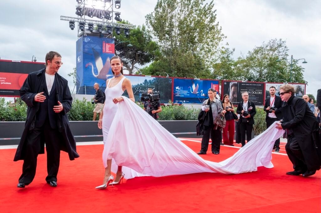Natasha Poly showcases the dramatic train of her custom Diesel gown at the Venice Film Festival.