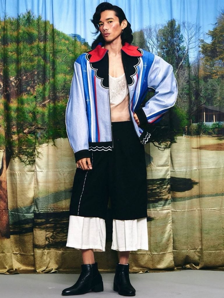 Randolf look featuring a striped blue jacket with a red collar and cropped black-and-white trousers.