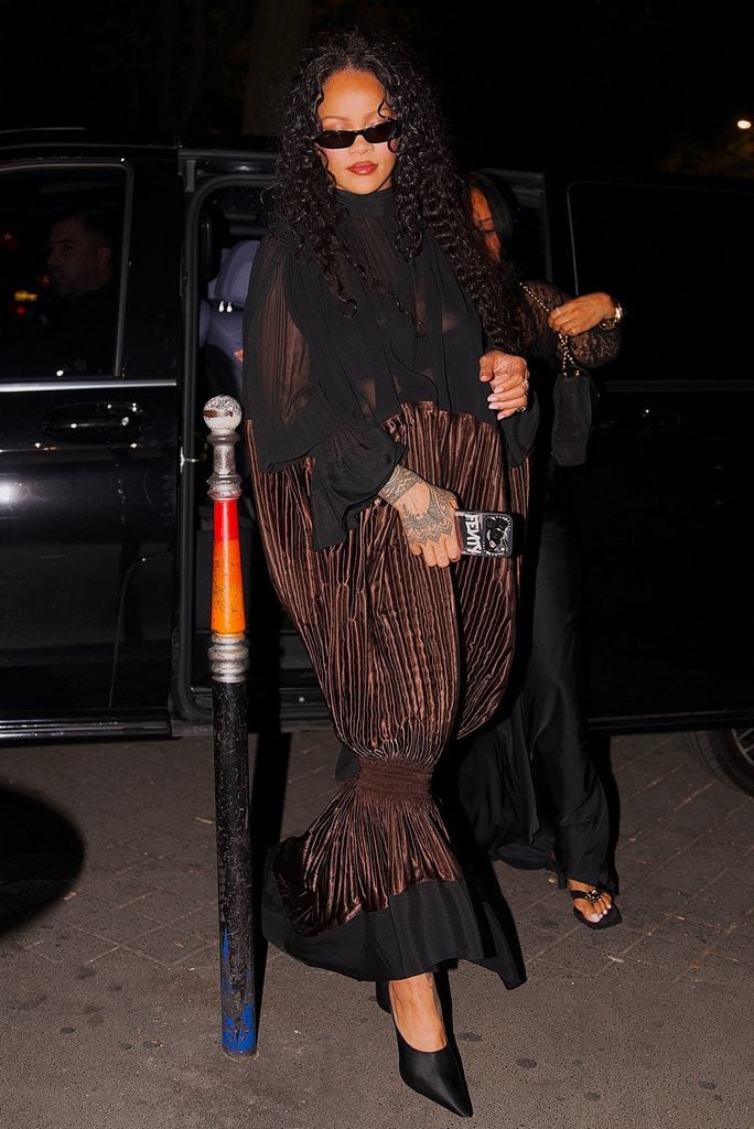 Rihanna wearing a sheer black and metallic brown pleated Ferragamo Fall 2026 dress in Paris after attending Céline Dion’s concert.